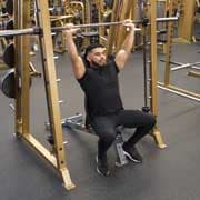 Tense muscles of hands under load. Man doing exercise for biceps in the gym.